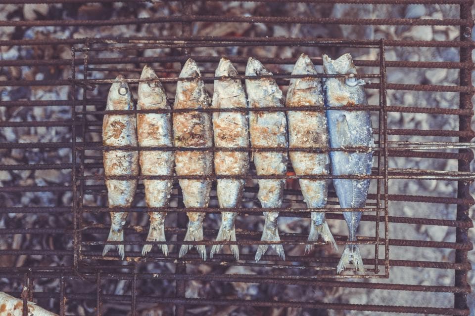 Whole sardines on a grill rack