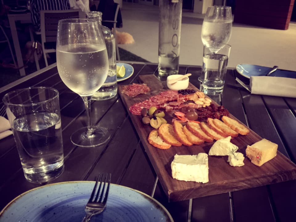 A sharing board of cheese and cured meats with wine