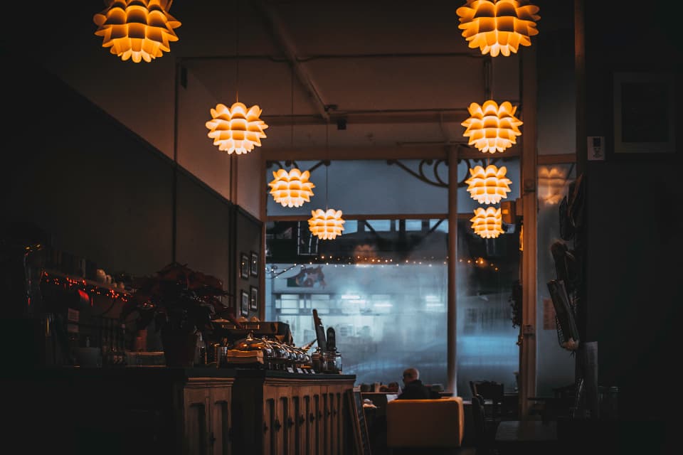 The dining room at dusk under warm pendant lights